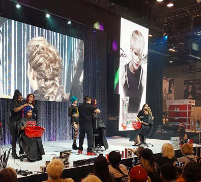 Image of models and hairstylists on stage with onlookers