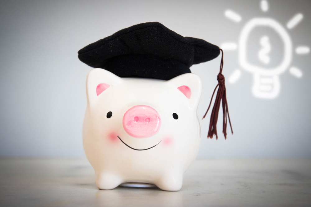 pink and white piggy bank with graduate cap