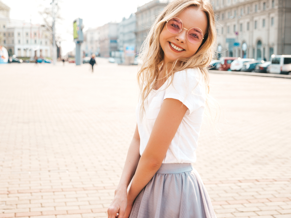 blonde girl wearing pink sunglasses and smiling