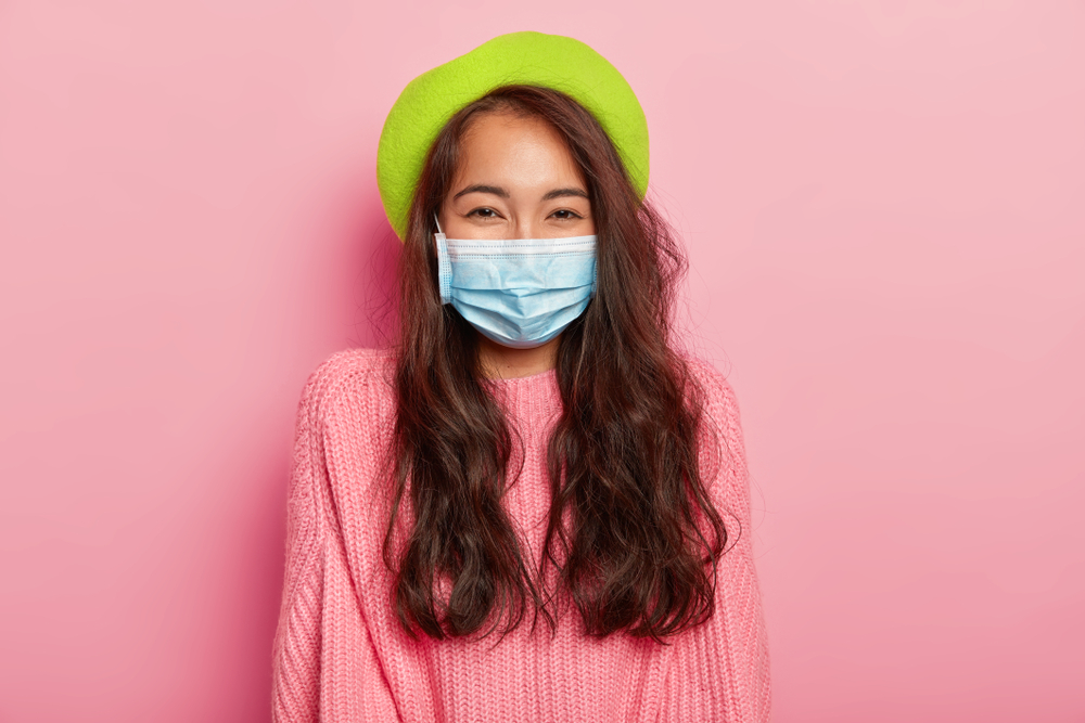 woman smiling while wearing a face mask