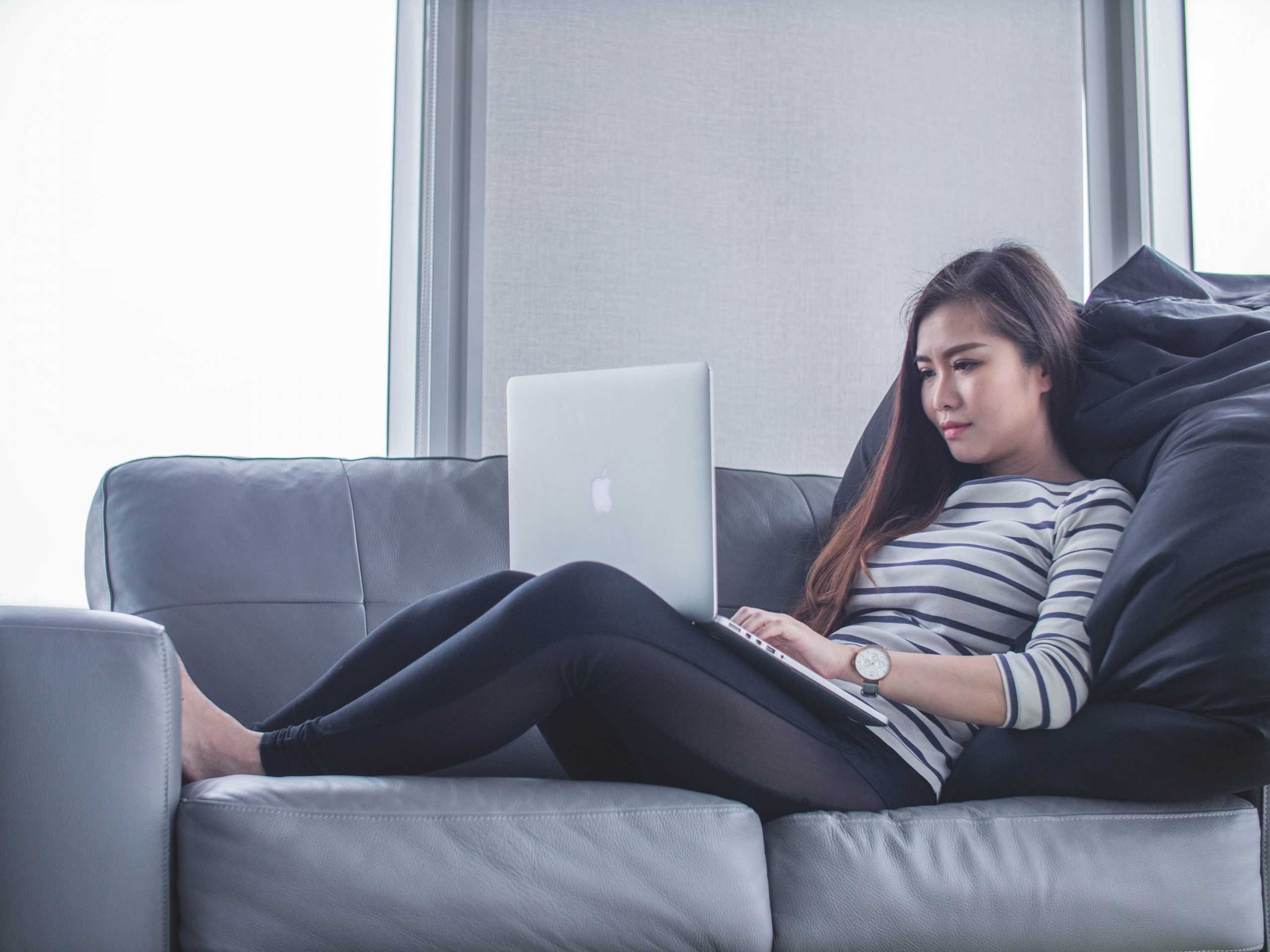 woman on couch using laptop