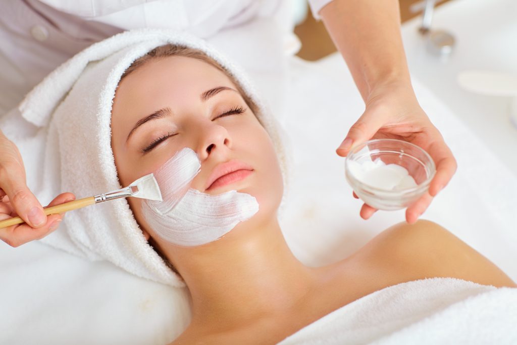 young woman getting a facial in a spa