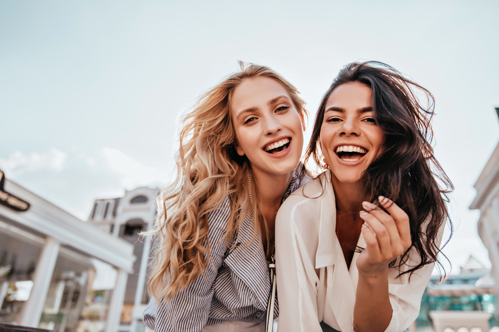 two girls laughing and looking at camera
