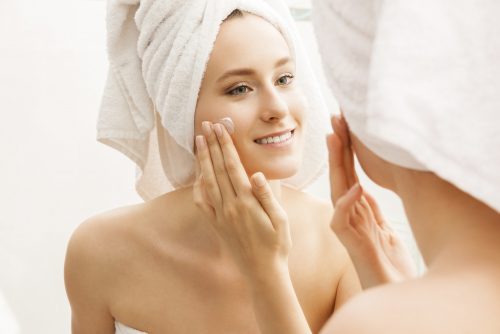 woman applying skincare product to face