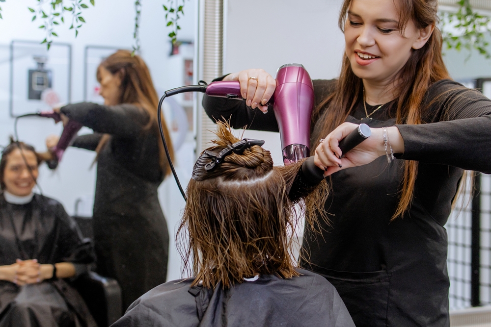 Woman blowdrying hair in a salon